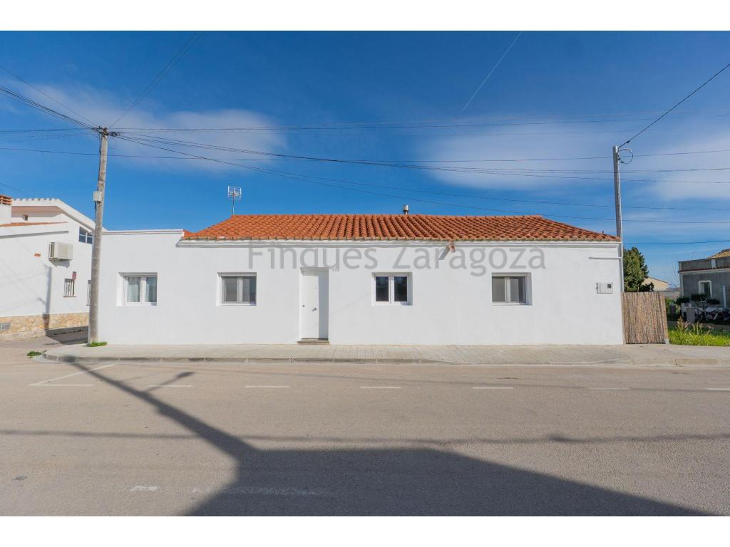 *Casa con licencia turísticaDescubre esta casa con alma mediterránea de 145 m² construidos (125 m² útiles) sobre una amplia parcela de 753 m² donde lo rústico y lo contemporáneo se encuentran en equilibrio perfecto.Espacios amplios y muy luminosos, con techos altos de vigas vistas y detalles de ladrillo original que aportan carácter y calidez. El salón-comedor de concepto abierto con chimenea de leña invita a compartir con una estética natural basada en madera, fibras y tonos neutros que transmiten calma y estilo.La cocina, integrada y funcional, combina líneas limpias con detalles artesanales y almacenaje práctico, ideal tanto para el día a día como para recibir invitados. Los dormitorios mantienen la misma atmósfera serena y minimalista, con acabados cuidados, iluminación suave y puertas correderas que aportan carácter. El baño sigue una línea moderna y elegante, con ducha amplia, microcemento y elementos en madera que suman calidez.Para asegurar confort durante todo el año, cuenta con ventanas de aluminio con doble acristalamiento, que ayudan a aislar tanto de la temperatura como del ruido exterior, además de radiadores para una climatización agradable en los meses fríos.En el exterior, un amplio patio de grava y vegetación ofrece privacidad y amplitud para disfrutar del aire libre. La joya: una zona chill-out/comedor exterior con pérgola, barbacoa y espacios pensados para disfrutar del sol, las sobremesas y las noches de verano.Una vivienda única, lista para entrar a vivir, perfecta para quienes buscan diseño, autenticidad y vida al aire libre.